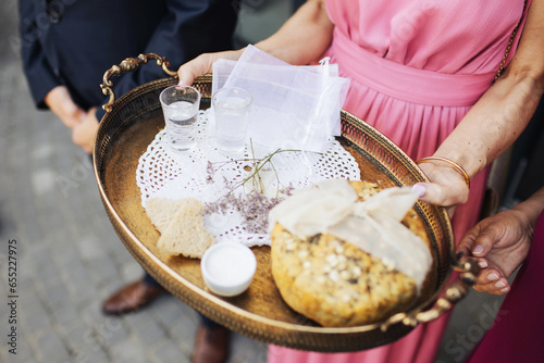 Wedding tradition in Poland and Russia. Parents welcome bride and groom with bread, vodka and salt. Decorative tray with food and alcohol. European culture background. Newlyweds greetings.