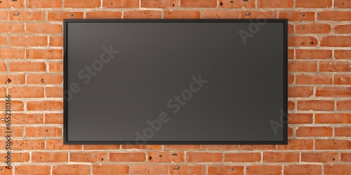 Fototapeta Naklejka Na Ścianę i Meble -  Large tv television flat screen display monitor on brick wall background with copy space, technology or media template