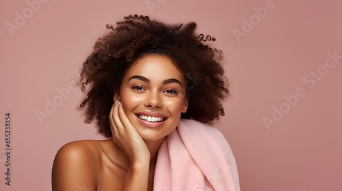 Joyful woman indulges in skincare with a facial scrub.Wrapped in a towel, radiating a carefree vibe.
Her pleased glance is directed aside, full of happiness.All set against a vibrant pink backdrop.  photo