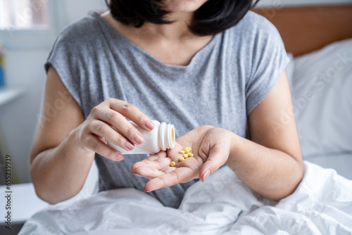 closeup woman hand taking overdose antihistamines pills photo