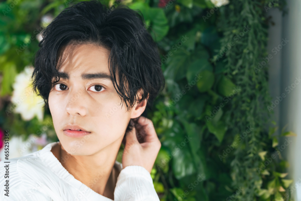 Beauty portrait of young Asian man with green plants. Cosmetics and skin care concept. Beauty portrait of young Asian man with green plants. Cosmetics and skin care concept.