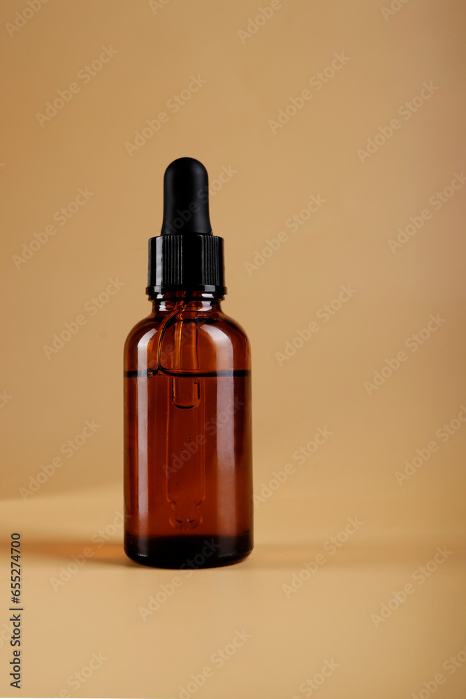 serum bottle with pipette on nude colored background