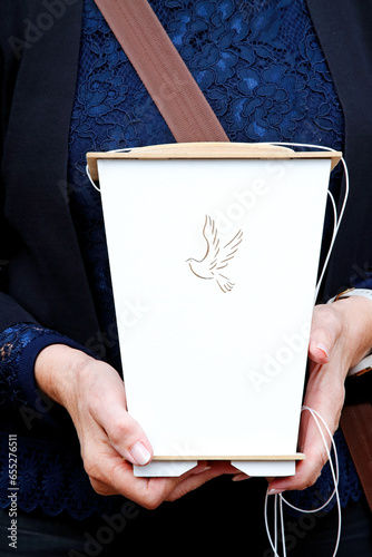 A woman carries an urn in her hands during a burial ceremony
