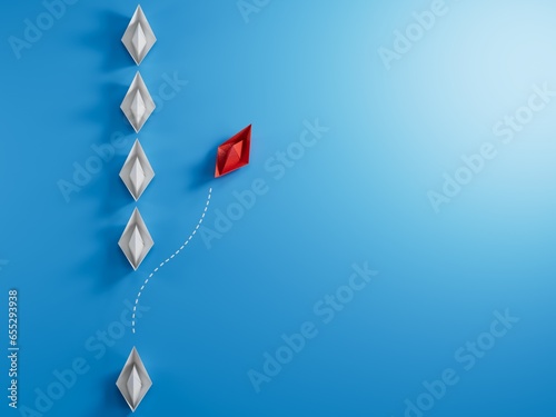 Group of white paper boat in one direction and one red paper boat pointing in different way on blue background. Business concept for new ideas, creativity, innovation and solution.
