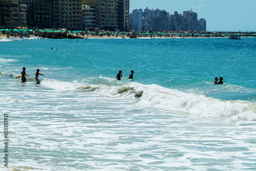 Obraz na plátně Boys go  to water in alexandria and new buildings in distance  on coast