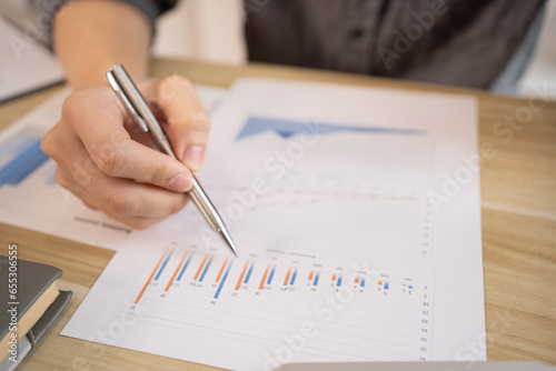 Close-up of a pen pointing at a graph, Financial statistics and calculating corporate returns in private offices, Market research reports and income statistics, Financial and Accounting concept.