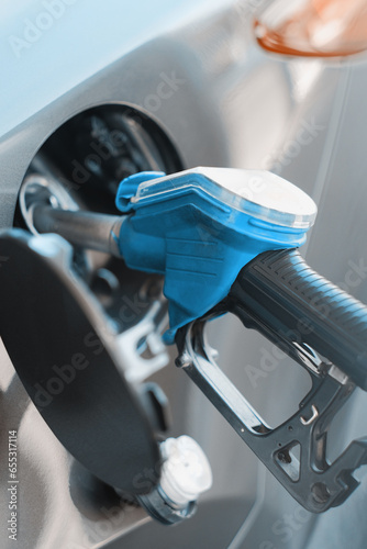 Close-up view of the process of refuelling the car at the gas station. Blue fuel gun at the gas station. Diesel gasoline fuel. Fuel up the gas tank