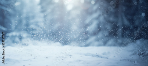 Winter scene with snowflakes falling and blurred forest in the background