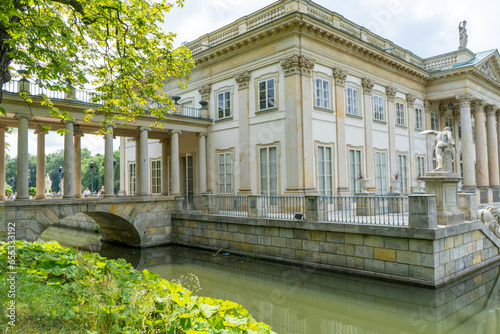 Lazienki Park with pond. Polish Lazienkowski or Lazienki Krolewskie is the polish park. Lake house with pond. The palace on the water is a monument of architecture. photo