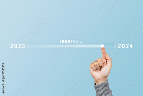 Hand touching loading bar for countdown to 2024. Loading year 2023 to 2024. Start concept