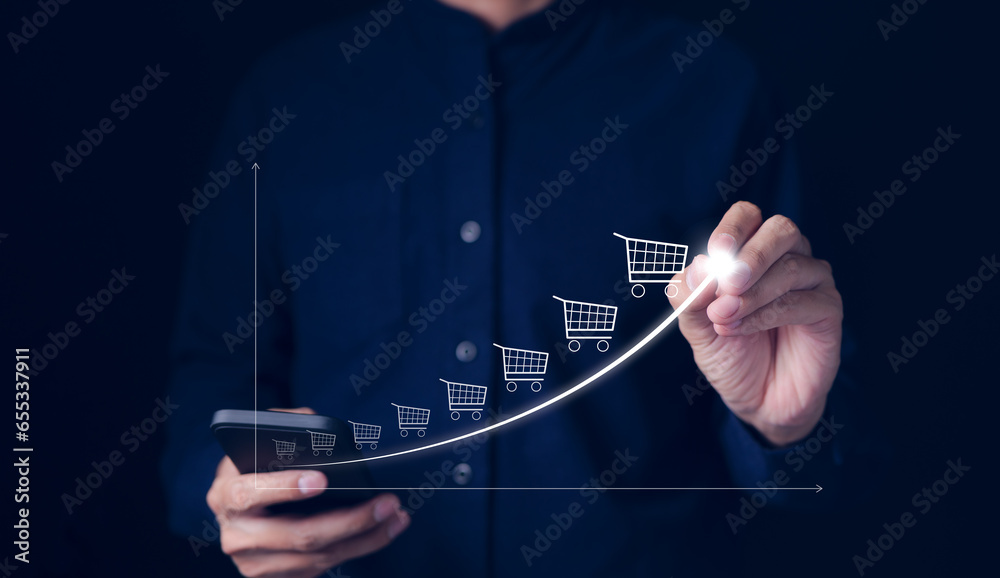Online sale business growth concept. Businessman drawing increasing trend graph of sale volume with bigger shopping trolley cart. long term investment growth goal, Digital Marketing Strategies, - obrazy, fototapety, plakaty 