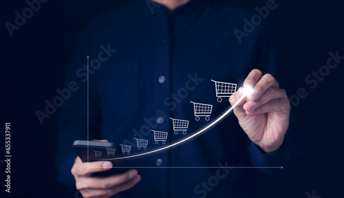 Online sale business growth concept. Businessman drawing increasing trend graph of sale volume with bigger shopping trolley cart. long term investment growth goal, Digital Marketing Strategies,