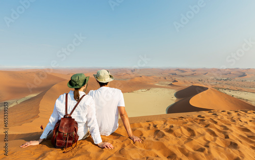 Travellers in Africa, couple on romantic vacation in Namibia, looking at beautiful Namib desert landscape