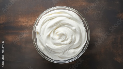 Whipped cream for cakes in glass bowl, top view, copy space