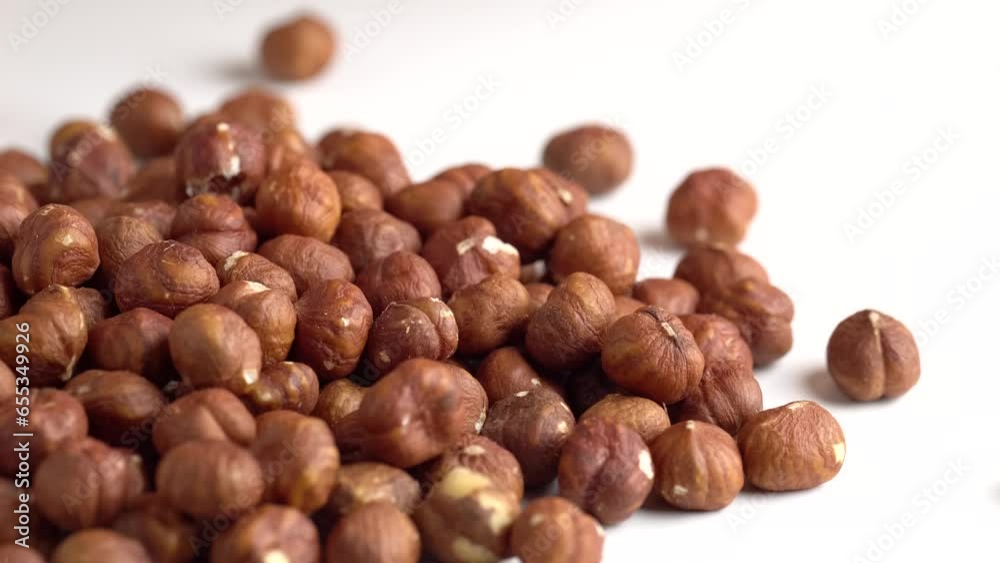 Hazelnuts falling on the white table. Organic snack Hazelnuts falling on the white table. Organic snack