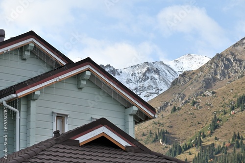Alpine home roof structure with mountains on the background