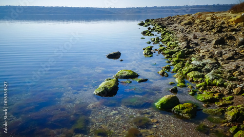 Rocky Shore of the Tiligul Estuary with algae emerging from under the water during the drying out of the estuary