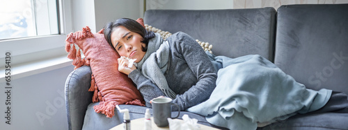 Fotografia Sick woman lying on sofa at home, catching cold