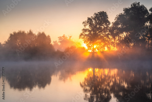 Sunrise on a foggy lake © alexugalek