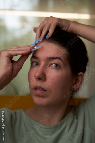 Woman is massaging her face scraper gua sha.