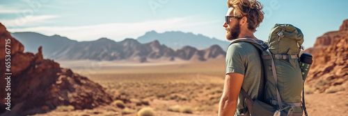 Male hiker with backpack hiking in mountain desert landscape 