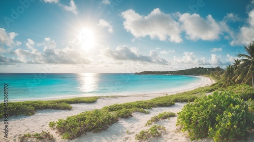 Panoramic view of a beautiful beach with white sand, blue sea water and blue sky with clouds on a sunny day.