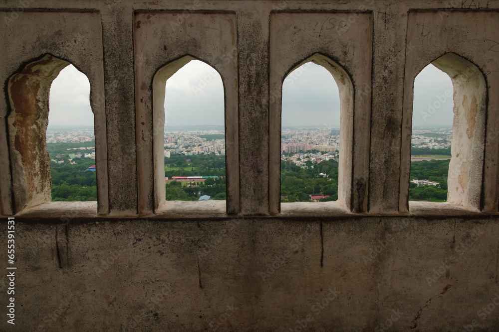A partial view of Hyderabad city through the window in the wall of Baradari (Darbar Hall), Golconda fort, Hyderabad, Telangana, India