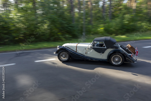old classic vintage retro automobile driving away on ther road, sun reflecting in detailed parts. panoraming motion blur, pano shot © Kamil Krawczyk