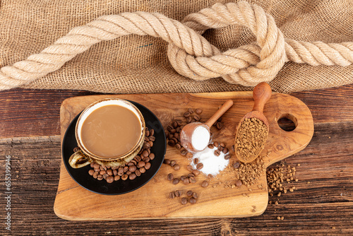 Instant granulated coffee. Coffee beans on or instant granulated coffee. Dry instant coffee in a black ceramic dish next to coffee beans isolated. photo