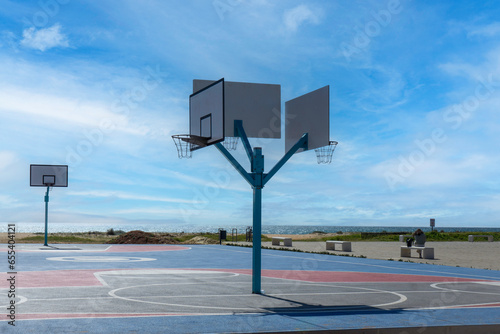 An outdoor basketball court beside the beach and seafront in Vilamoura, Portugal.