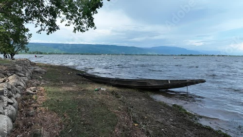 view of a boat driving on a lake with a background of mountains, tanguar haor, Sunamganj, Bangladesh. photo