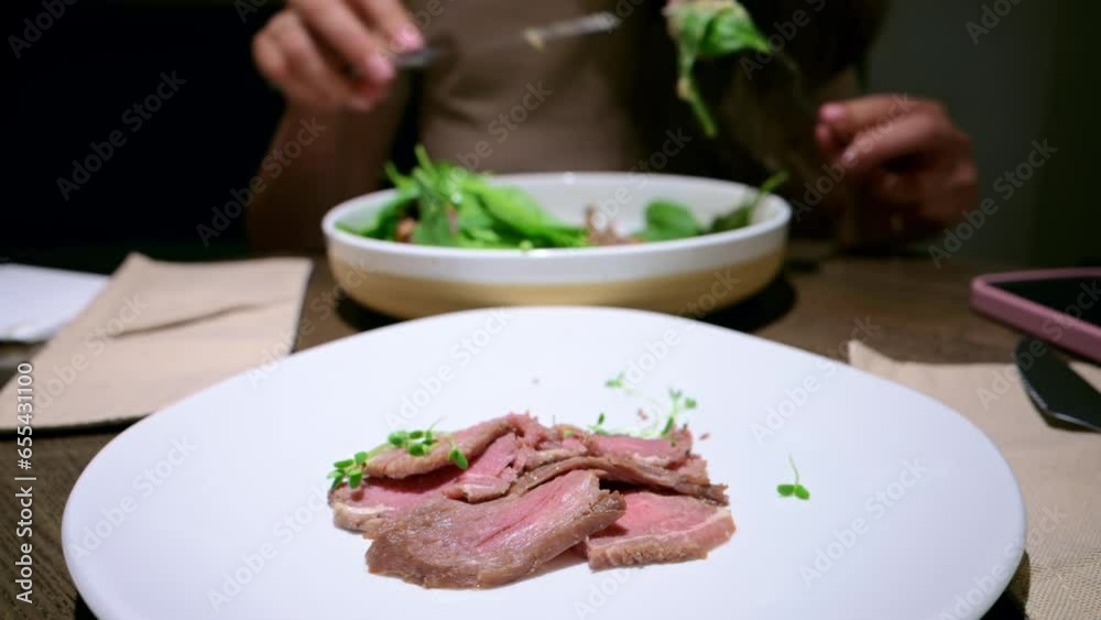 Woman eating beef meat salad at a restaurant