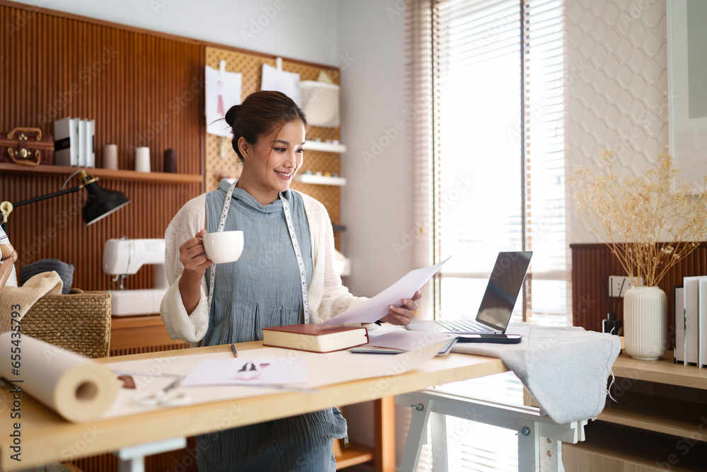 Fashion seamstress woman drinking coffee and checking sketch model of fashion clothes on paper.. Fashion seamstress woman drinking coffee and checking sketch model of fashion clothes on paper..