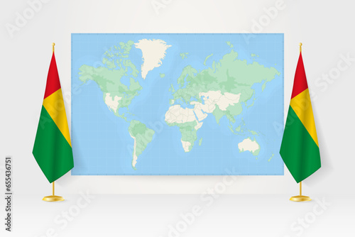 World Map between two hanging flags of Guinea-Bissau flag stand.