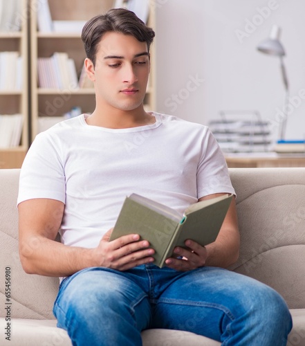 Man reading book sitting in couch sofa © Elnur