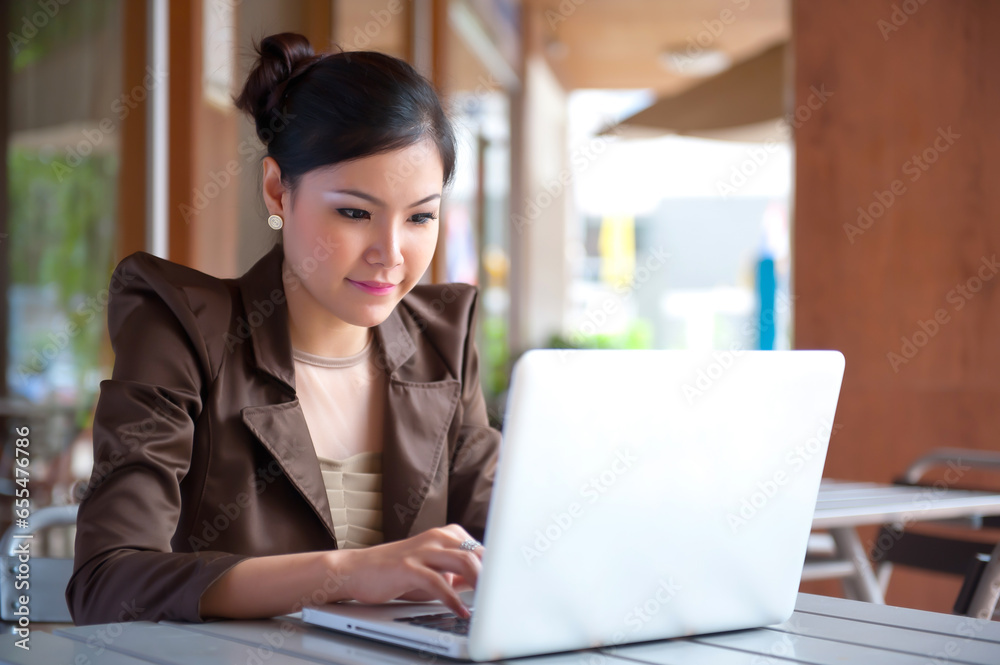 Profile view of a young smiling woman using a laptop over a white background
Profile view of a young smiling woman using a laptop over a white background