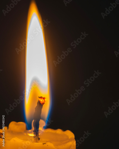 Closeup of a burning candle in the dark with copy space