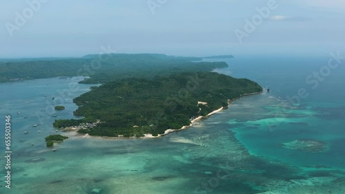 Coastline with sandy beach in tropical island and azure ocean water and fish farms. Barobo, Surigao del Sur. Philippines. photo