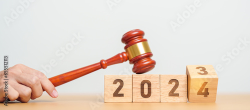 2023 chcnge to 2024 year block with judge gavel on table. Law, lawyer, judgment, justice auction and bidding concept photo