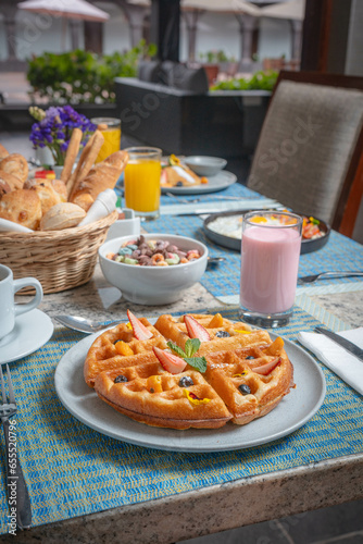 Desayuno saludable en acompañado de huevos, ensalada de frutas, panques tortillas, wafles salchichas. café jugos en un hotel. photo