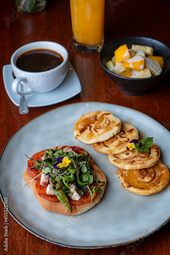 Desayuno de panqueques con café y ensalada de frutas en el restaurante del un hotel de lujo.