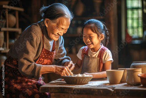 Asian grandmother teaching her granddaughter cooking skills in a traditional kitchen. Concept off bonding  love  and heritage