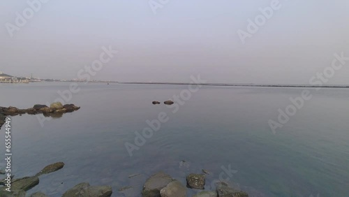 View of pier of rocks by the sea