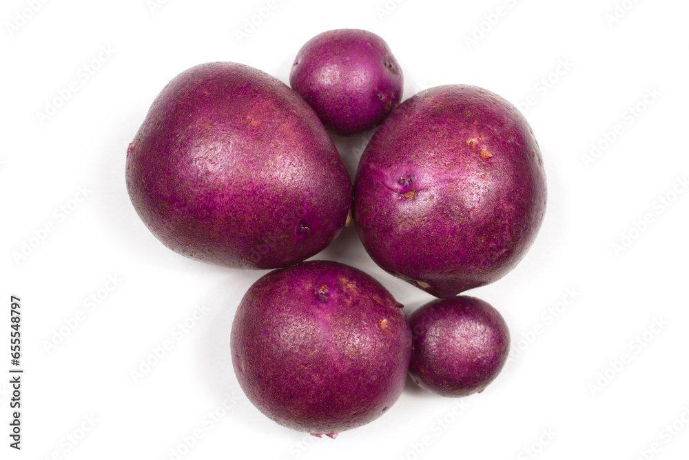 Tubers of purple potatoes on a white background. Purple potatoes close-up. Tubers of purple potatoes on a white background. Purple potatoes close-up.