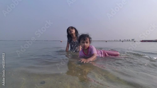 Two happy kids playing on beach at the day time