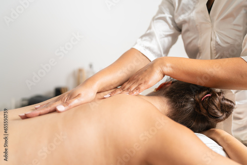 Masseur massaging the back of a woman lying on stretcher