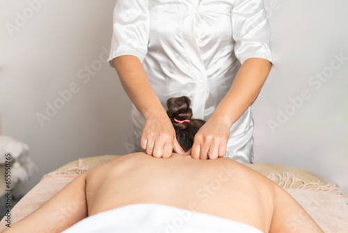 Worker massaging the back of a woman in a salon