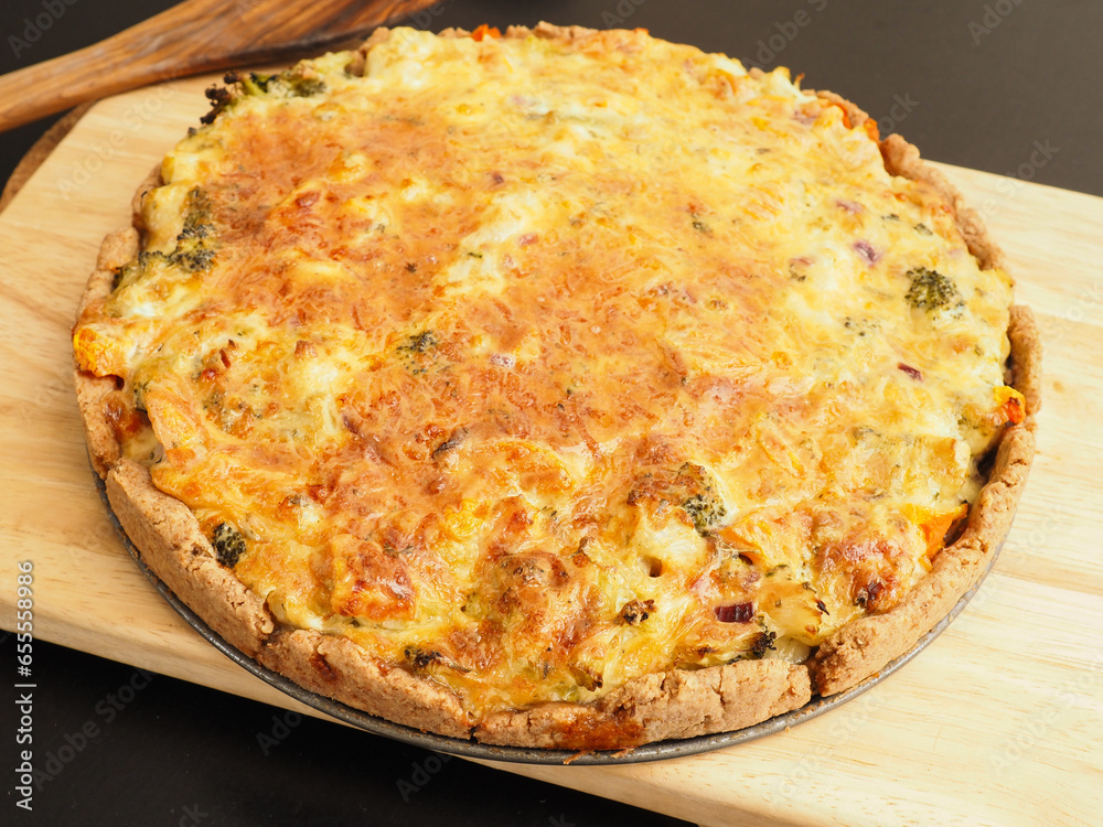 Tasty organic vegetable quiche on a cutting board in a kitchen, healthy eating or diet concept, vegetarian food
