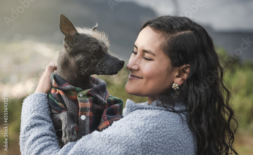 Portrait of a woman and her Peruvian Hairless Dog in nature at sunset photo