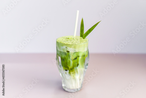 blended brew matcha latte with straw on light gray background